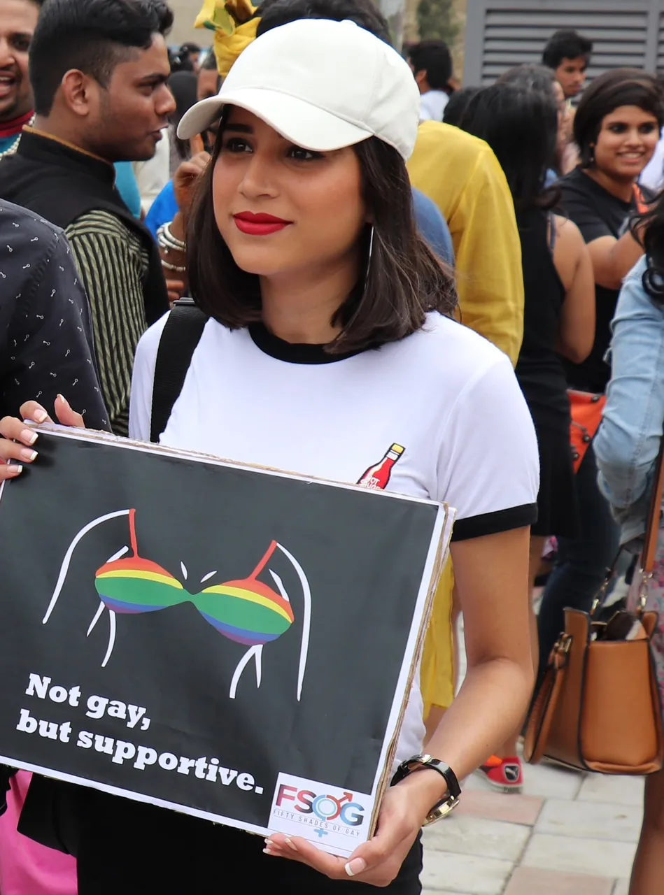 Shubham at a Pride march, holding an FSOG sign that says Not gay, but supportive