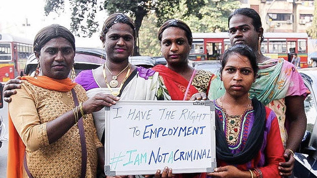 Trans women at a Mumbai traffic junction holding an #IAmNotACriminal whiteboard