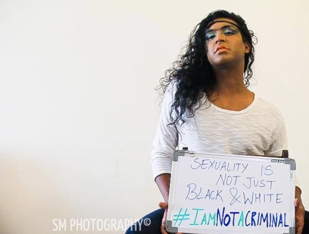 Fashion designer Jason holding a whiteboard that reads Sexuality is not just black and white