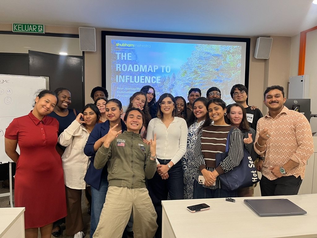 Shubham with a workshop group under The Roadmap to Influence slide